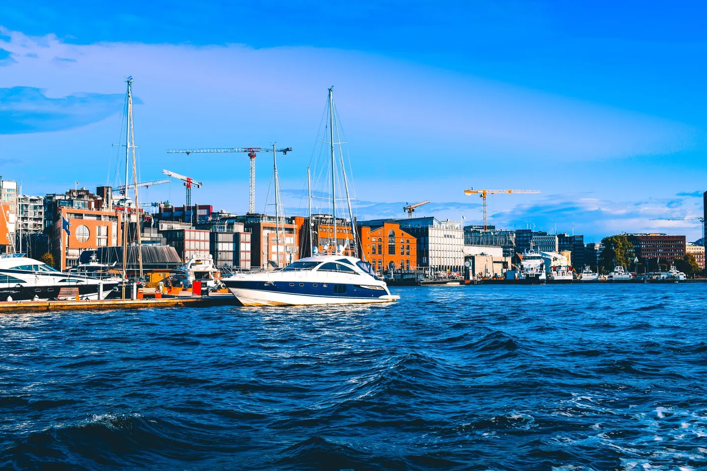 Sailing boats in Oslo’s harbour with the buildings of Aker Brygge behind them