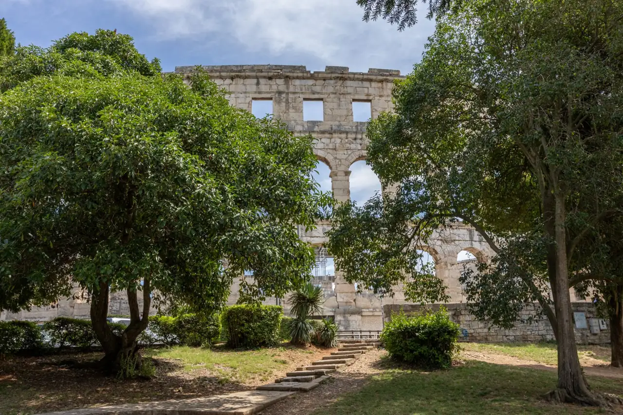 Pula’s Roman amphitheatre rising above trees