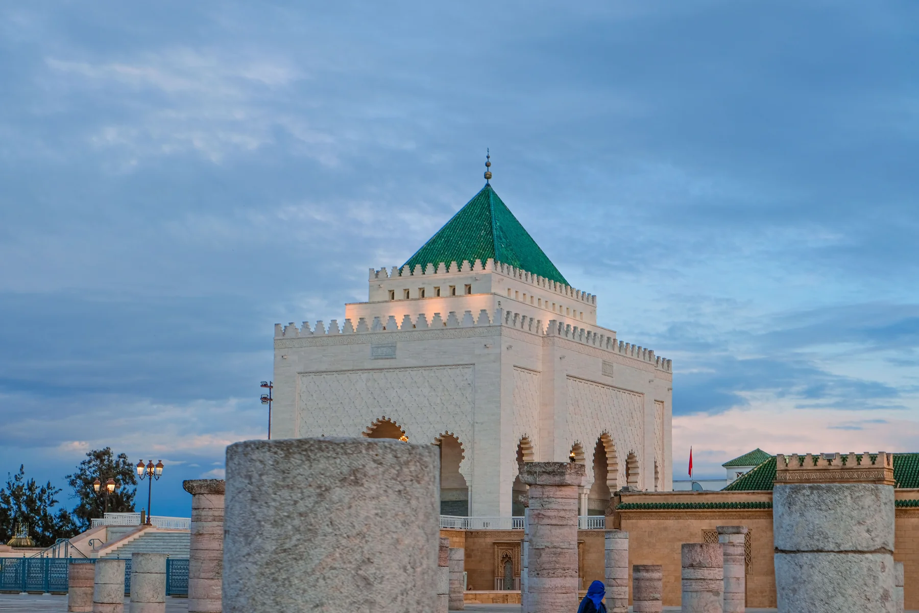 The green-roofed Mausoleum of Mohammed V behind the columns of the unfinished Hassan mosque in Rabat