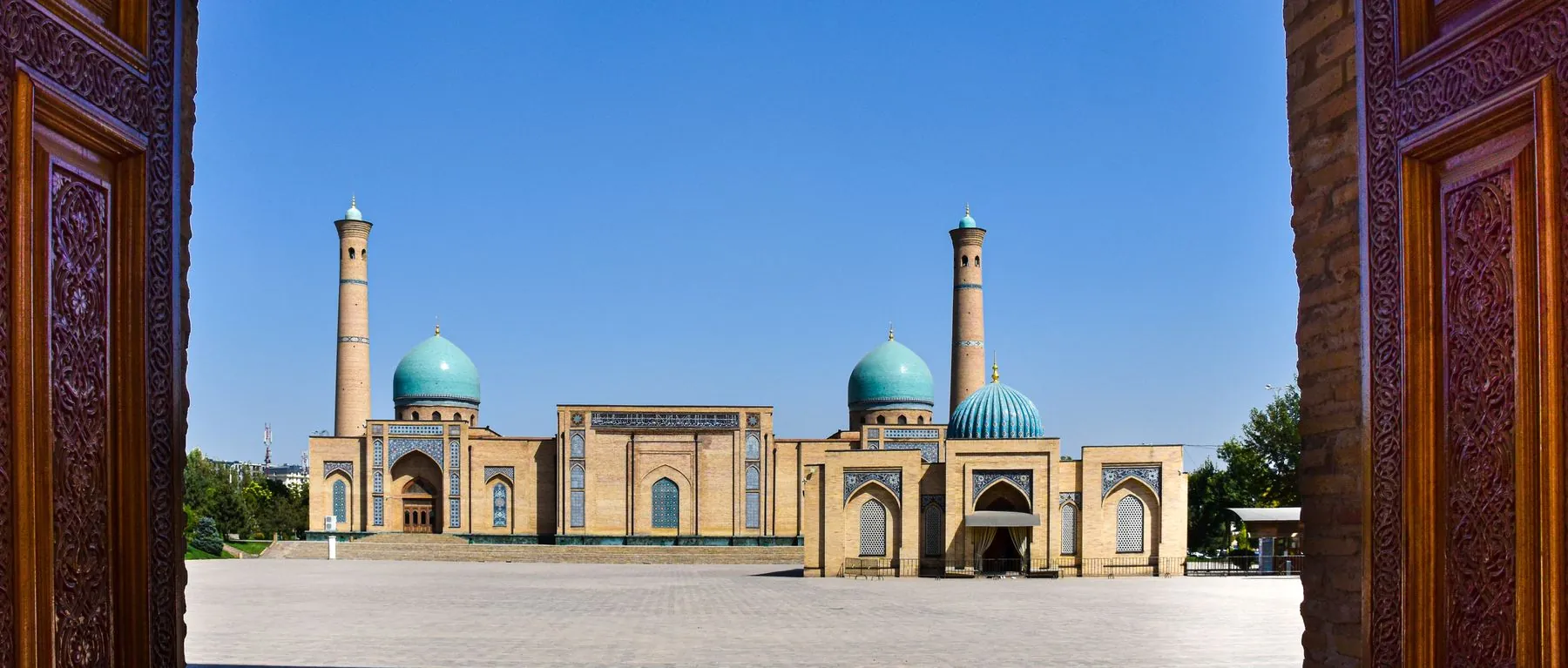 Hazrati Imam Mosque and its turquoise domes seen through an ornate gateway in Tashkent